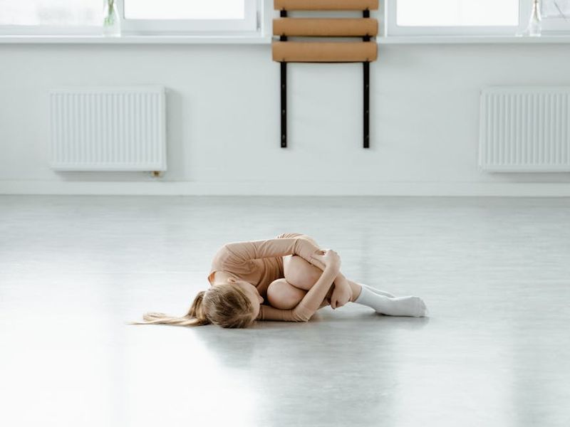 Minimalist yoga studio with dark walls and soft ruby lighting